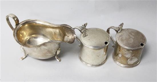 A pair of George V silver mustard pots by William Comyns & Sons, London, 1929, with blue glass liners and a later silver sauceboat.